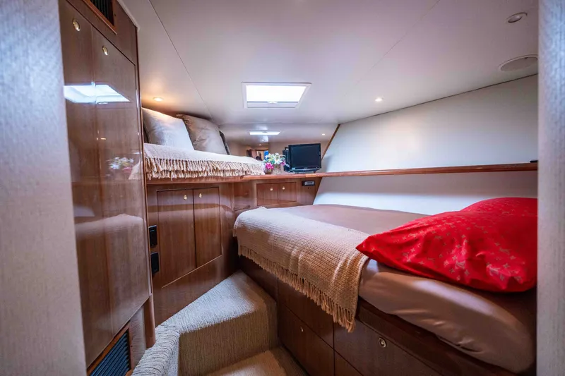 Slide: The Image of Luxurious cabin interior of a 2005 Viking 56 Convertible yacht, featuring cozy beds and elegant wood finishes. - 17