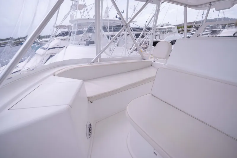 Slide: The Image of Interior view of a 2005 Viking 56 Convertible yacht with white seating and clear windows. - 28
