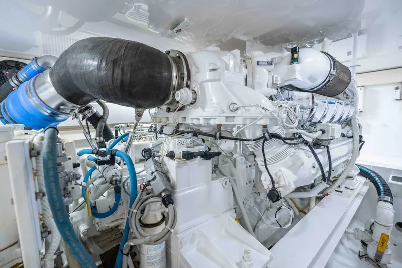 Slide: The Image of Engine room of a 2005 Viking 56 Convertible yacht, showcasing complex machinery and piping. - 33