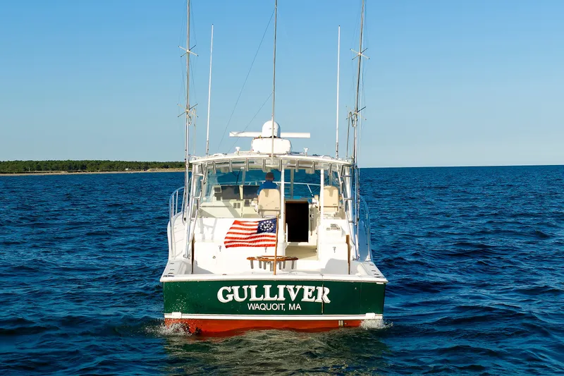 Slide: The Image of 2006 Cabo Yachts 40 Express boat on open water, rear view with American flag. - 4