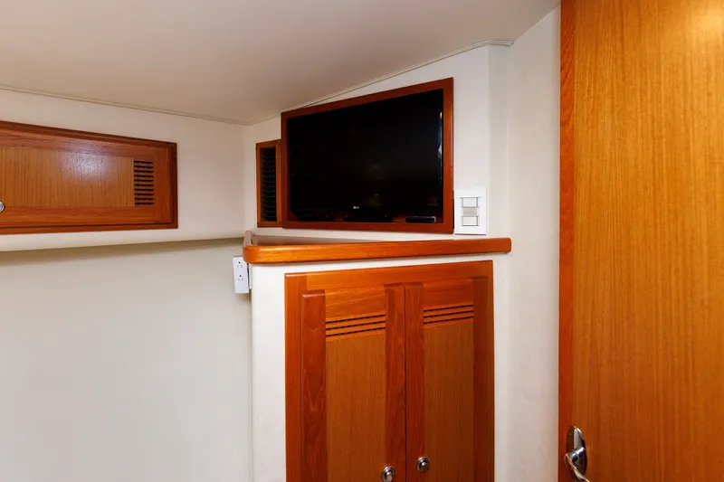 Slide: The Image of Interior of 2006 Cabo Yachts 40 Express with wooden cabinetry and mounted TV. - 35