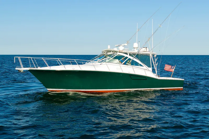 Slide: The Image of 2006 Cabo Yachts 40 Express cruising on open sea under clear blue sky. - 3