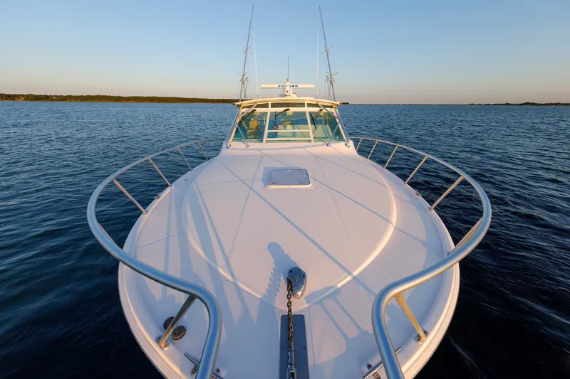 Slide: The Image of 2006 Cabo Yachts 40 Express on calm water at sunset, showcasing sleek design. - 40