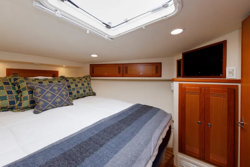Slide: The Image of Luxurious cabin interior of 2006 Cabo Yachts 40 Express with cozy bedding and elegant wood finishes. - 34