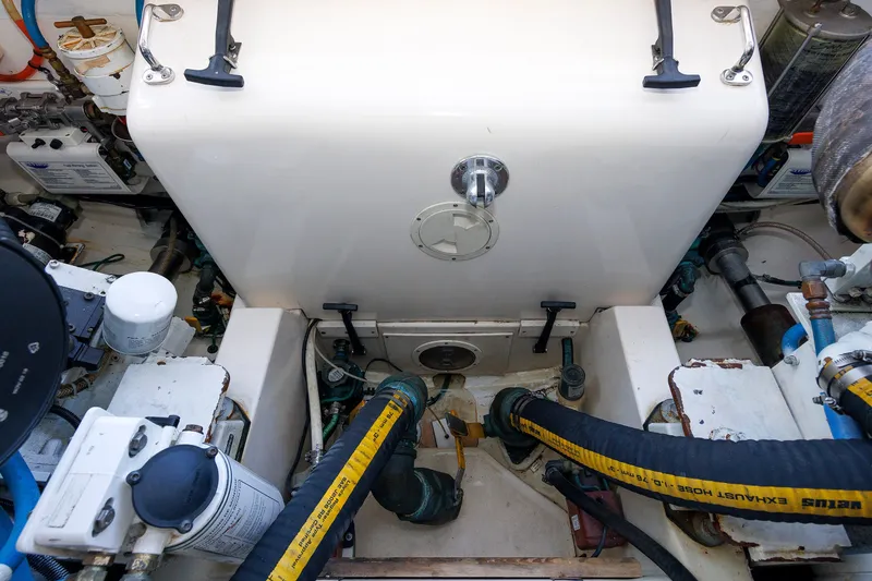 Slide: The Image of Engine room of a 2006 Cabo Yachts 40 Express, showcasing mechanical components and hoses. - 56