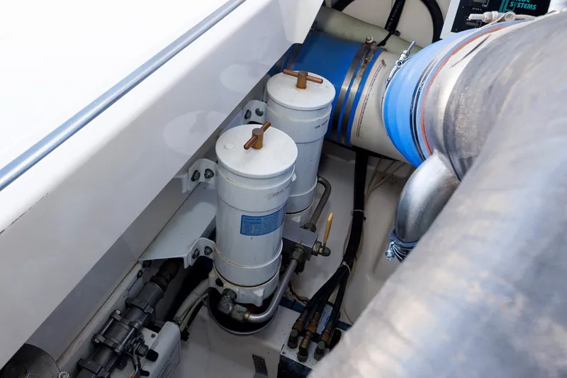 Slide: The Image of Engine compartment of 2006 Cabo Yachts 40 Express, showcasing filters and hoses. - 55