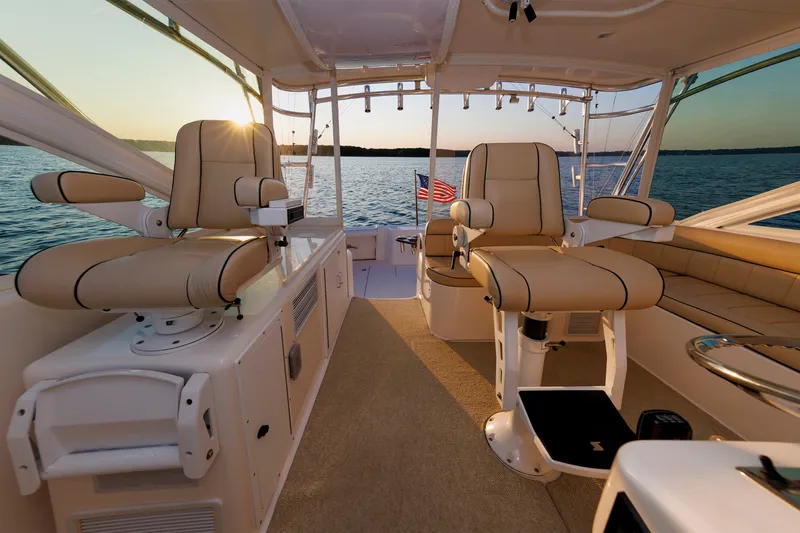 Slide: The Image of Luxurious 2006 Cabo Yachts 40 Express interior with plush seating, overlooking serene waters at sunset. - 16