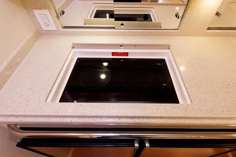 Slide: The Image of 2006 Cabo Yachts 40 Express kitchen with sleek cooktop and modern countertop design. - 29