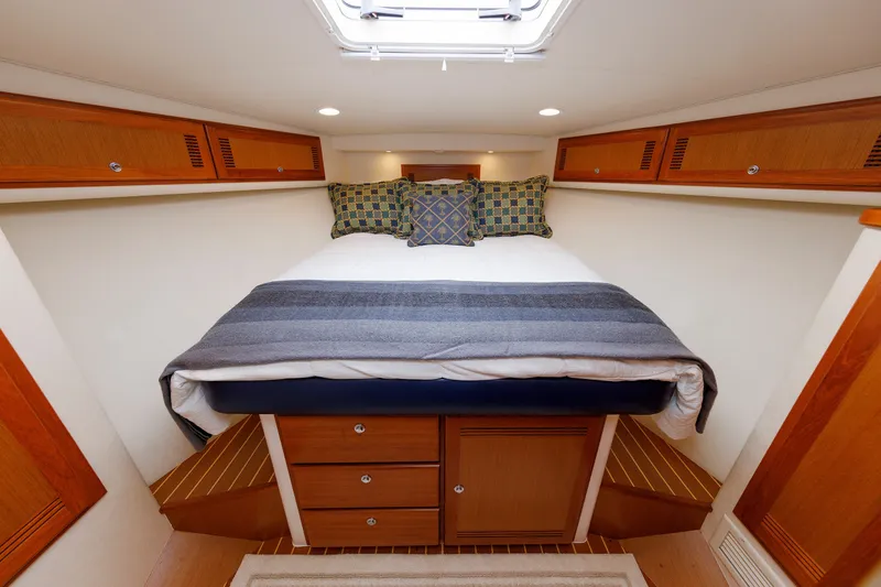 Slide: The Image of Luxurious cabin interior of 2006 Cabo Yachts 40 Express with cozy bedding and wooden cabinetry. - 32
