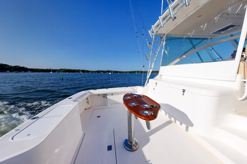 Slide: The Image of 2006 Cabo Yachts 40 Express on open water, featuring spacious deck and fishing rod holders. - 9