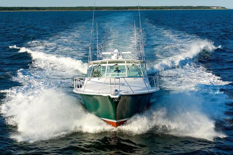 Slide: The Image of 2006 Cabo Yachts 40 Express cruising on open water, creating a dynamic wake. - 5