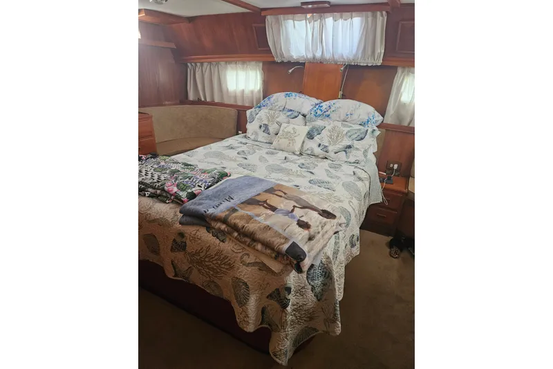 Slide: The Image of Cozy bedroom interior of 1986 Jefferson 42 SE Sundeck Motor Yacht with nautical-themed bedding. - 14
