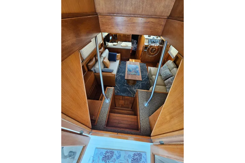 Slide: The Image of Interior view of 1986 Jefferson 42 SE Sundeck Motor Yacht, featuring cozy seating and wooden finishes. - 24