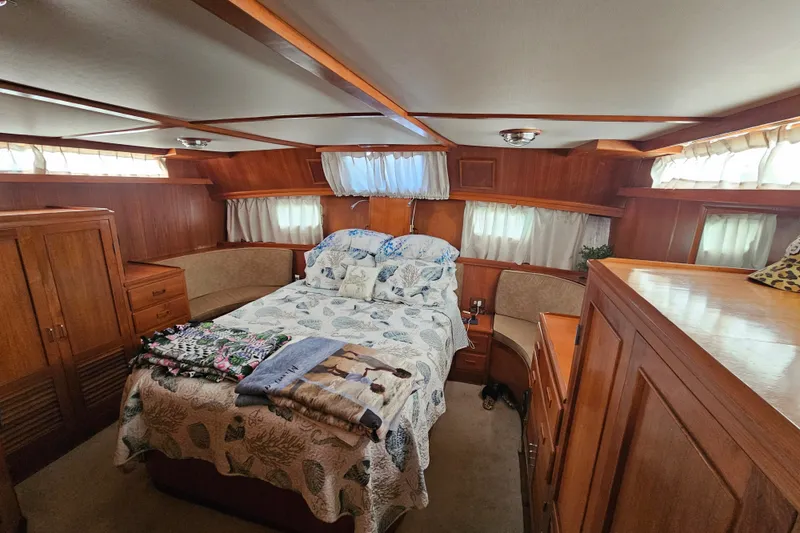 Slide: The Image of Cozy bedroom in 1986 Jefferson 42 SE Sundeck Motor Yacht with wood paneling and floral bedding. - 30