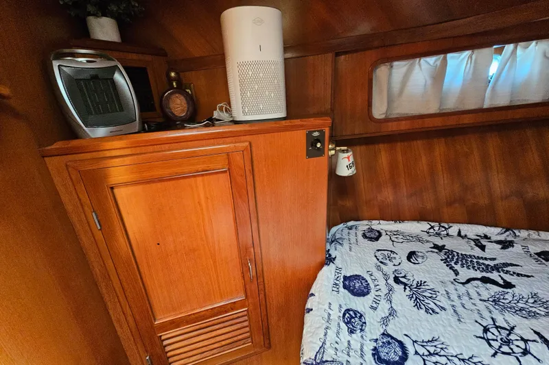 Slide: The Image of Interior of 1986 Jefferson 42 SE Sundeck Motor Yacht with wooden cabinetry and nautical-themed bedding. - 38