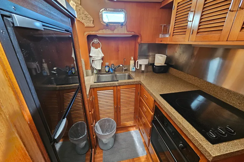 Slide: The Image of Compact kitchen in 1986 Jefferson 42 SE Sundeck Motor Yacht with modern appliances and wooden cabinetry. - 34