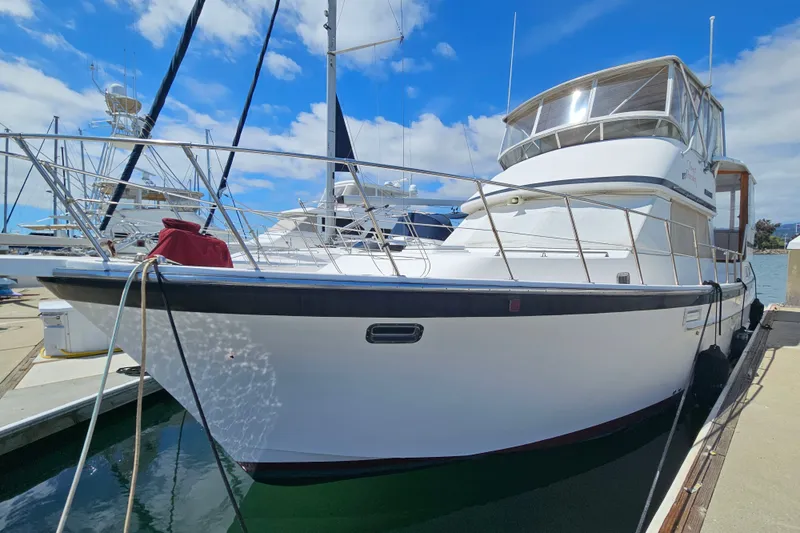 Slide: The Image of 1986 Jefferson 42 SE Sundeck Motor Yacht docked at marina under blue sky. - 3
