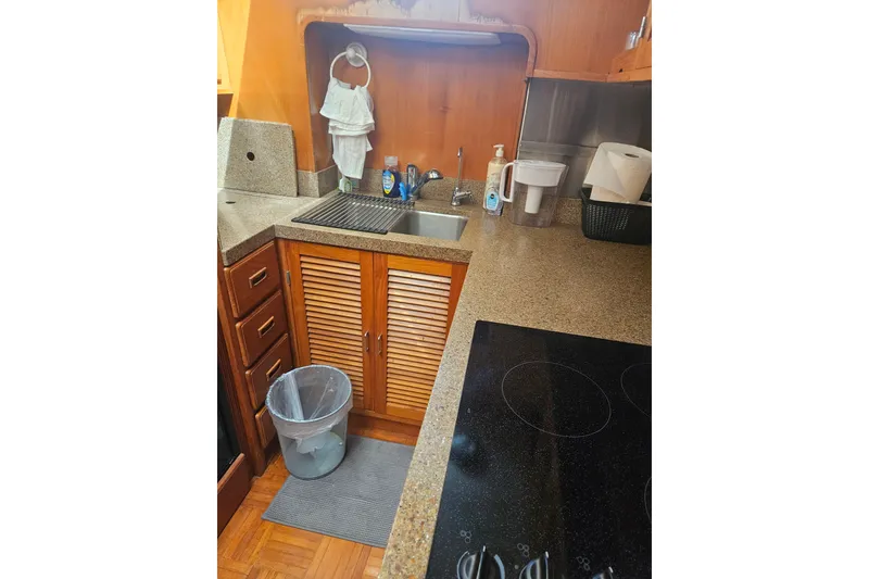 Slide: The Image of 1986 Jefferson 42 SE Sundeck Motor Yacht kitchen with sink, stove, and wooden cabinets. - 8