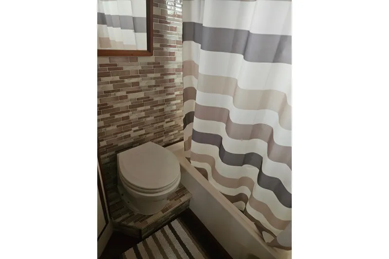 Slide: The Image of Bathroom interior of 1986 Jefferson 42 SE Sundeck Motor Yacht with striped shower curtain. - 15