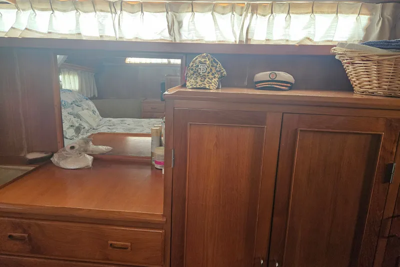 Slide: The Image of Interior of 1986 Jefferson 42 SE Sundeck Motor Yacht with wooden cabinetry and cozy bedding. - 17