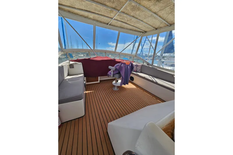 Slide: The Image of 1986 Jefferson 42 SE Sundeck Motor Yacht interior with cushioned seating and wooden flooring. - 21