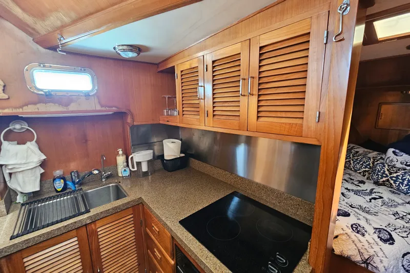 Slide: The Image of Compact kitchen in 1986 Jefferson 42 SE Sundeck Motor Yacht with wooden cabinets and modern appliances. - 35