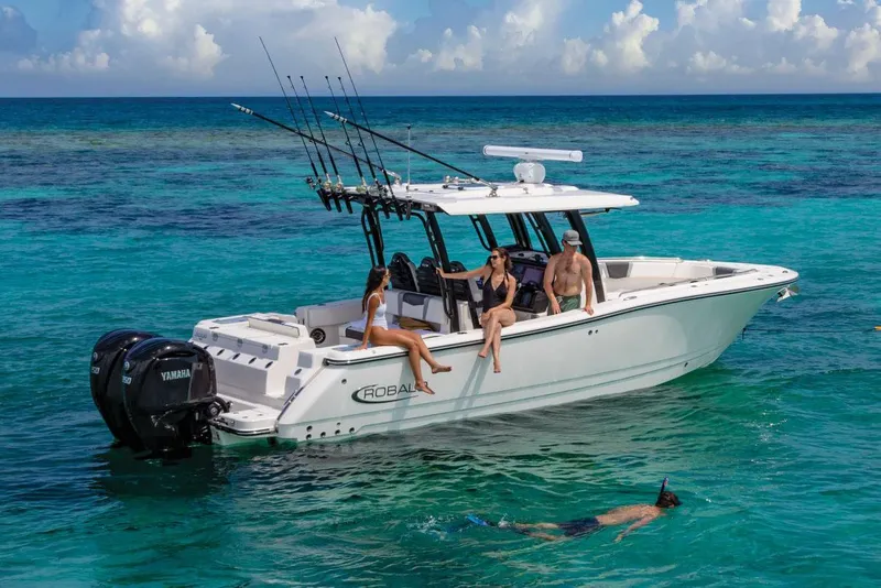 Slide: The Image of Manufacturer Provided Image: 2025 Robalo R300 Center Console boat with people relaxing and snorkeling in clear blue water. - 0