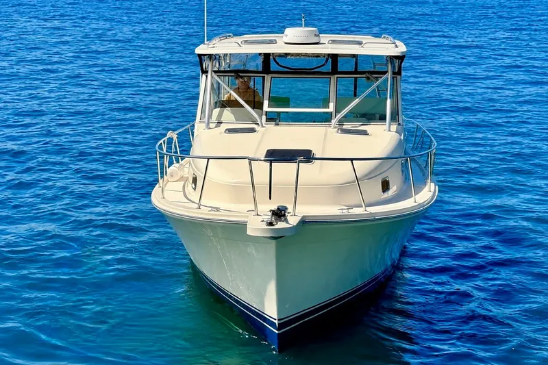 Slide: The Image of 2006 Mainship Pilot 34 Sedan boat on clear blue water, front view. - 4