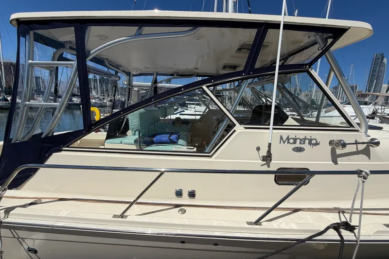 Slide: The Image of 2006 Mainship Pilot 34 Sedan docked at a marina, showcasing sleek design and spacious interior. - 6