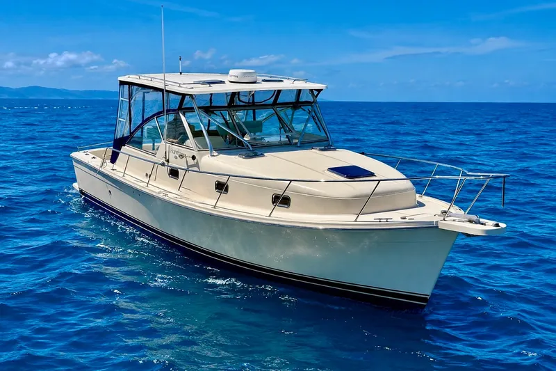 Slide: The Image of 2006 Mainship Pilot 34 Sedan cruising on clear blue ocean waters. - 1