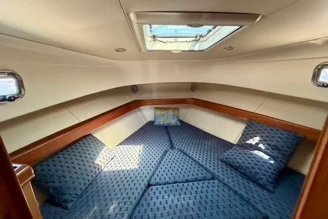 Slide: The Image of Interior cabin of 2006 Mainship Pilot 34 Sedan with blue patterned bedding and skylight. - 19