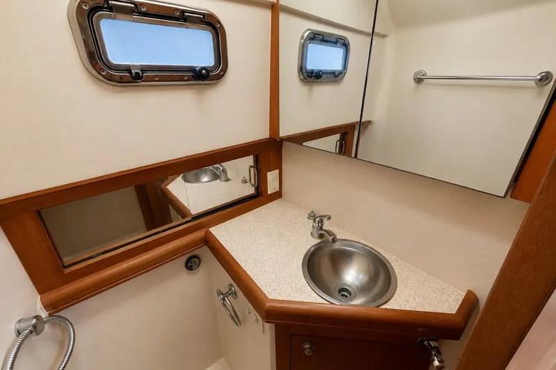 Slide: The Image of 2006 Mainship Pilot 34 Sedan bathroom with stainless steel sink and porthole window. - 20