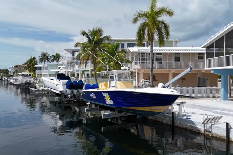 Slide: The Image of 2006 SeaVee 340B boat docked by waterfront homes with palm trees. - 21