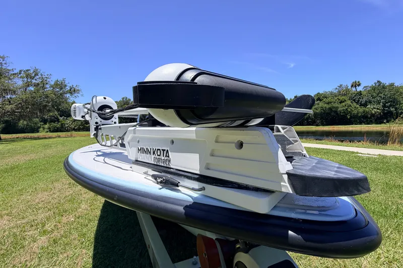 Slide: The Image of 2021 Chittum Skiffs Islamorada 21 with Minn Kota Fortrex motor on grassy landscape. - 22
