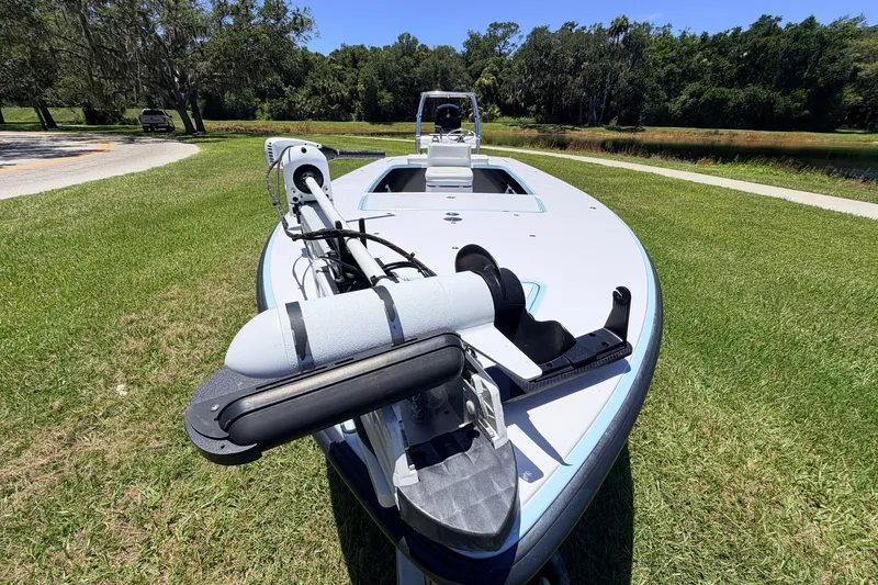 Slide: The Image of 2021 Chittum Skiffs Islamorada 21 boat on grass, featuring a trolling motor. - 21