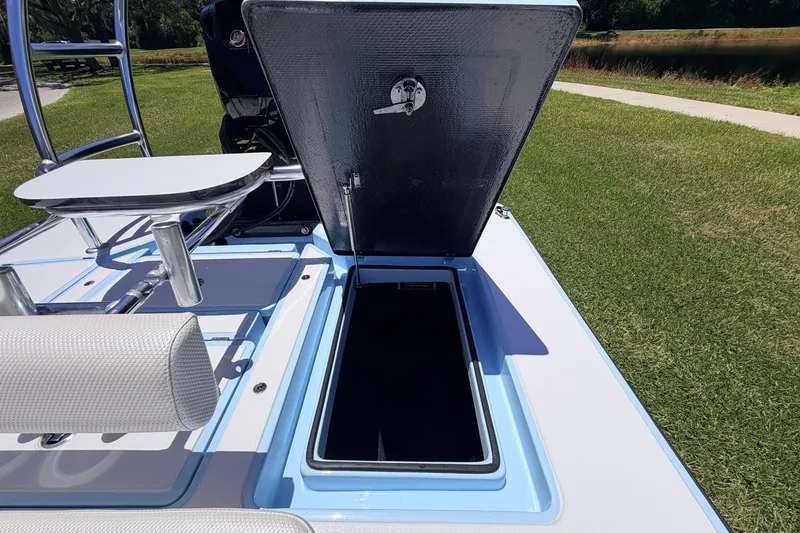 Slide: The Image of 2021 Chittum Skiffs Islamorada 21 boat with open storage compartment on grassy area. - 64