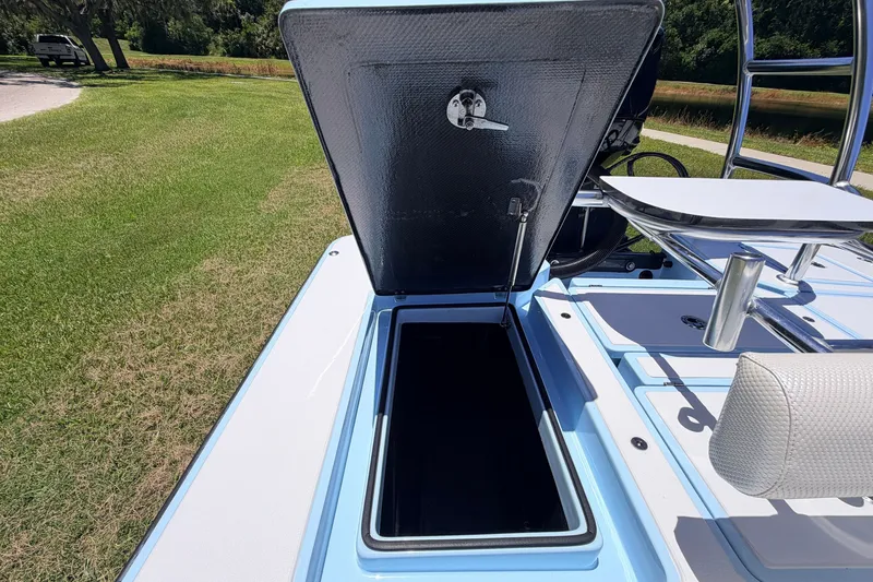 Slide: The Image of 2021 Chittum Skiffs Islamorada 21 boat storage compartment open on grassy area. - 59