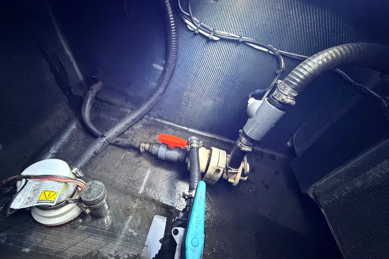 Slide: The Image of Bilge area of 2021 Chittum Skiffs Islamorada 21, showing pump and plumbing components. - 77