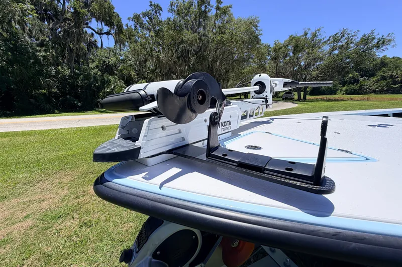 Slide: The Image of 2021 Chittum Skiffs Islamorada 21 with Minn Kota Fortrex motor, parked on grassy area. - 23