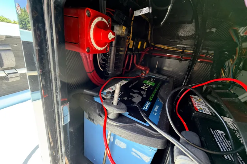 Slide: The Image of Electrical system inside a 2021 Chittum Skiffs Islamorada 21 boat, featuring batteries and wiring. - 49