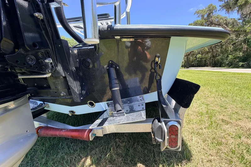 Slide: The Image of Rear view of 2021 Chittum Skiffs Islamorada 21 boat on trailer, showcasing motor and hull details. - 19