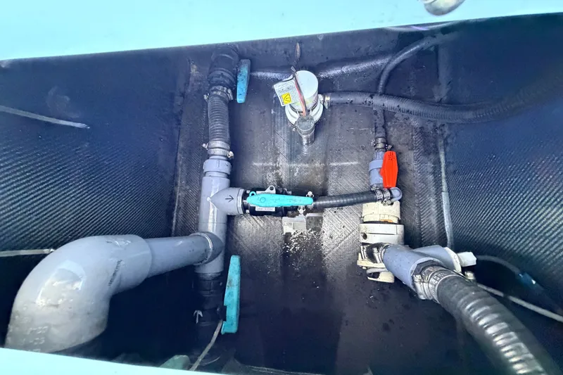 Slide: The Image of 2021 Chittum Skiffs Islamorada 21 plumbing system with pipes and valves in a boat compartment. - 75