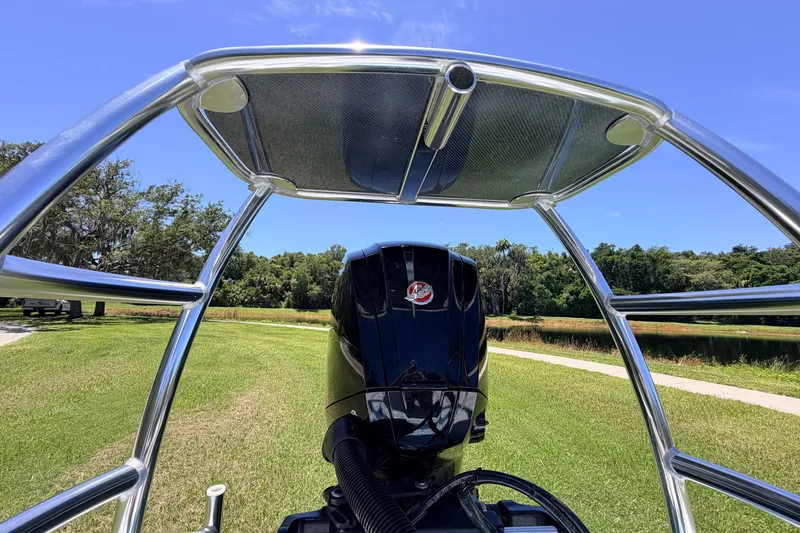 Slide: The Image of 2021 Chittum Skiffs Islamorada 21 boat engine and T-top, set against a scenic outdoor backdrop. - 80