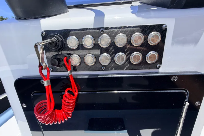 Slide: The Image of Control panel of 2021 Chittum Skiffs Islamorada 21 with red safety lanyard. - 46