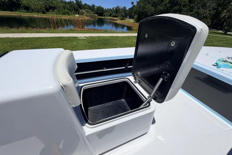 Slide: The Image of Open storage compartment on 2021 Chittum Skiffs Islamorada 21 boat, near a scenic lake. - 39