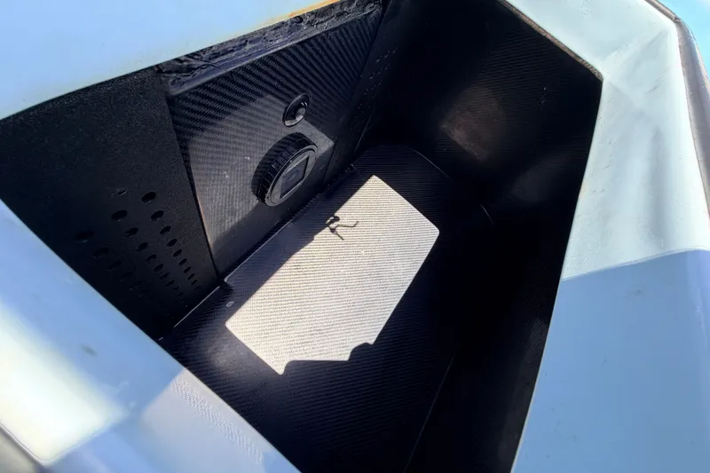 Slide: The Image of Storage compartment of 2021 Chittum Skiffs Islamorada 21, featuring a sleek, black interior design. - 72
