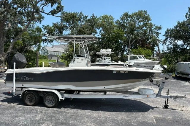 Slide: The Image of 2017 NauticStar 231 Coastal boat on trailer, parked outdoors. - 1