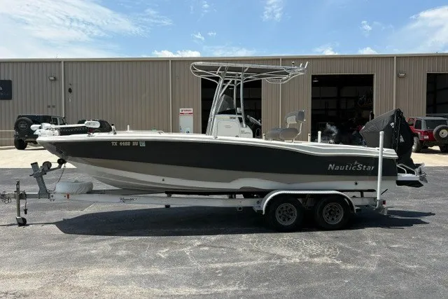 Slide: The Image of 2017 NauticStar 231 Coastal boat on trailer, parked outside a warehouse. - 5