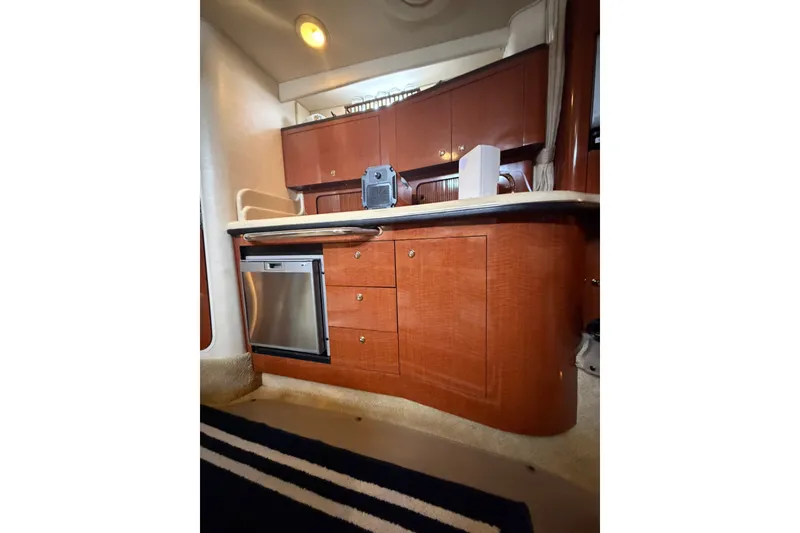 Slide: The Image of 2004 Sea Ray Sundancer 320 interior kitchen with wood cabinetry and stainless steel appliances. - 22