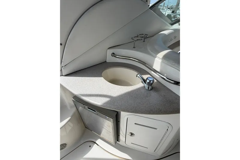 Slide: The Image of 2004 Sea Ray Sundancer 320 boat interior with sink, countertop, and storage cabinet. - 13